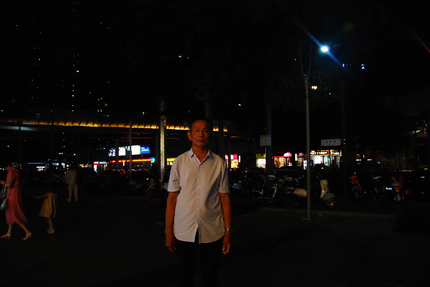 夜晚站在街边灯下的人